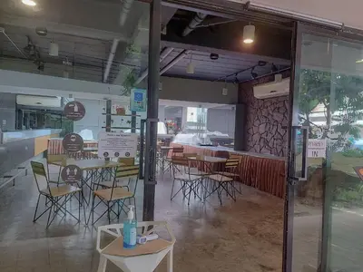 a restaurant with tables and chairs in a room at Peace Land Khaosan in Bangkok