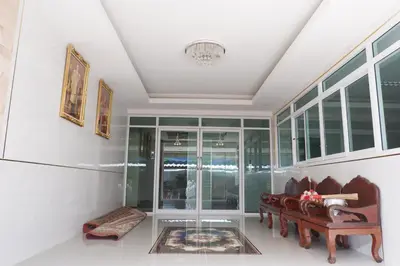 a living room with a table and chairs and windows at Tree Place in Bangkok