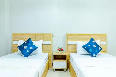 two beds with blue pillows in a room at Tree Place in Bangkok