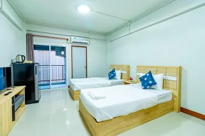 a bedroom with two beds and a television in it at Tree Place in Bangkok