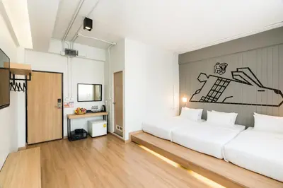 a bedroom with two beds and a painting on the wall at Marwin Villa in Bangkok