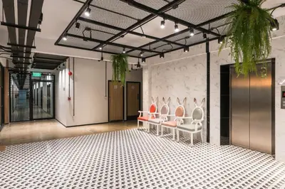 a group of chairs in a room with a wall at Marwin Villa in Bangkok