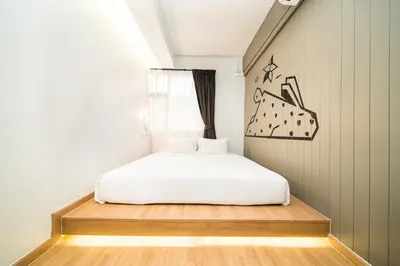 a bedroom with a white bed and a window at Marwin Villa in Bangkok
