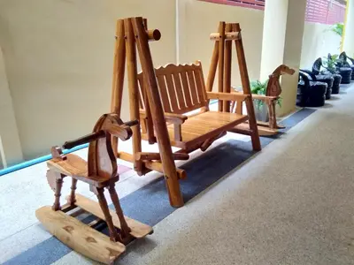 two wooden rocking chairs sitting in a room at Baan Wanchart in Bangkok