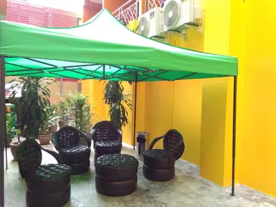 a group of chairs under a green umbrella at Baan Wanchart in Bangkok