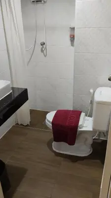 a bathroom with a toilet and a shower and a sink at Baan Wanchart in Bangkok