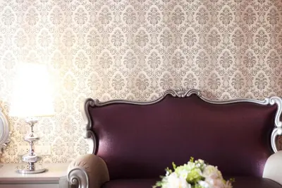 a living room with a couch and a wall with wallpaper at Villa De Khaosan by Chillax in Bangkok