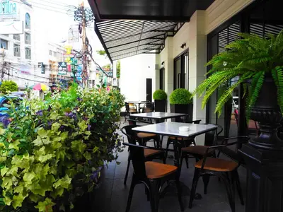 a patio with tables and chairs and plants at Villa De Khaosan by Chillax in Bangkok