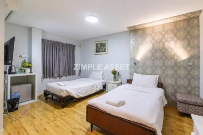 a bedroom with two beds and a tv in it at Tim Place - BTS Phra Khanong in Bangkok