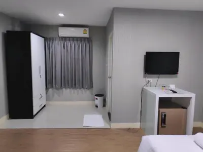 a living room with a television and a room with a bed at Tim Place - BTS Phra Khanong in Bangkok