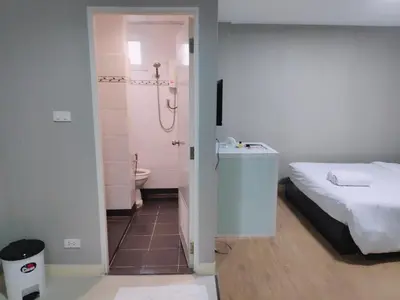 a bedroom with a bed and a bathroom with a shower at Tim Place - BTS Phra Khanong in Bangkok