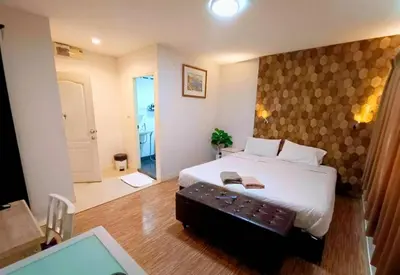 a bedroom with a large white bed with a keyboard at Tim Place - BTS Phra Khanong in Bangkok