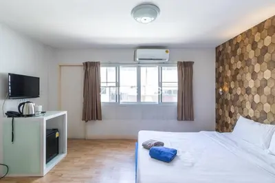 a hotel room with a bed and a television at Tim Place - BTS Phra Khanong in Bangkok