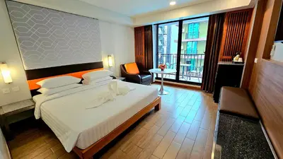 a hotel room with a bed and a balcony at Dynasty Grande Hotel in Bangkok