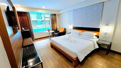 a bedroom with a large white bed in a room at Dynasty Grande Hotel in Bangkok