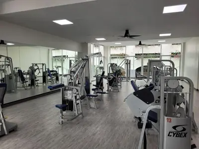 a gym with several treadmills and machines in it at Dynasty Grande Hotel in Bangkok