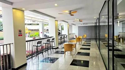 a restaurant with chairs and tables on a balcony at Dynasty Grande Hotel in Bangkok