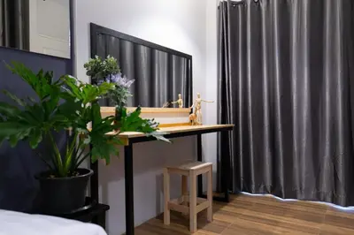 a bedroom with a table with a mirror and a plant at Mango 10 House in Bangkok