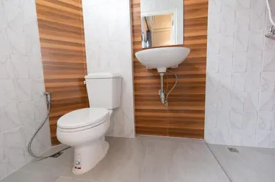 a bathroom with a white toilet and a sink at Mango 10 House in Bangkok