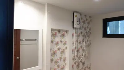 a bathroom with a shower with a floral shower curtain at Today Tonight in Bangkok