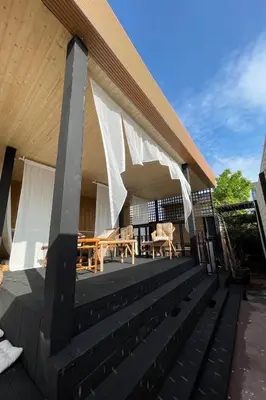 a deck with tables and chairs on a house at Blu Cabin Ari Stylish Gay Poshtel in Bangkok