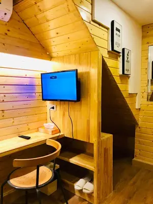 a cabin with a desk and a tv on a wall at Blu Cabin Ari Stylish Gay Poshtel in Bangkok