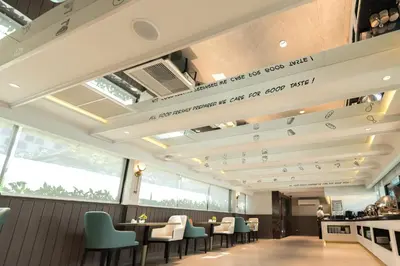 a restaurant with tables and chairs and a sign on the ceiling at Centre Point Plus Hotel Pratunam in Bangkok