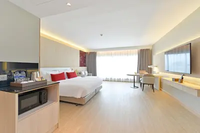 a hotel room with a bed and a television at Centre Point Plus Hotel Pratunam in Bangkok