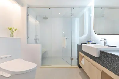 a bathroom with a shower and a sink and a toilet at Centre Point Plus Hotel Pratunam in Bangkok