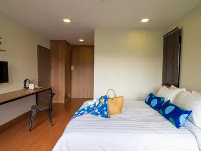 a bedroom with a white bed with blue pillows at Casa Luxe Hotel and Resident in Bangkok