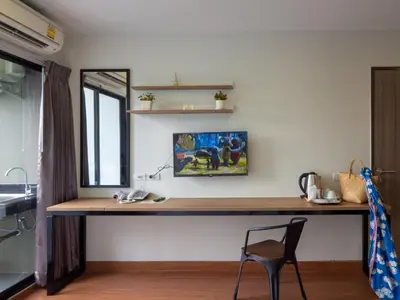 a desk in a room with a chair and a mirror at Casa Luxe Hotel and Resident in Bangkok