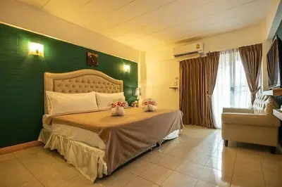 a bedroom with a bed with a green wall at SUDYOD HOTEL in Ban Bang Bamru