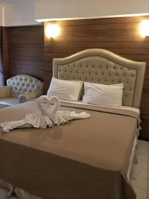 a bed with two towels in the shape of a heart at SUDYOD HOTEL in Ban Bang Bamru