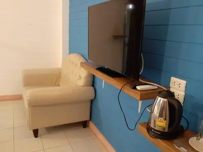 a room with a chair and a television on a table at SUDYOD HOTEL in Ban Bang Bamru