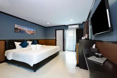 a bedroom with a large bed and a flat screen tv at The Breton Hotel Media in Bangkok