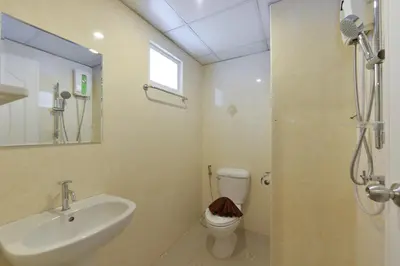 a bathroom with a sink and a toilet and a shower at The Breton Hotel Media in Bangkok