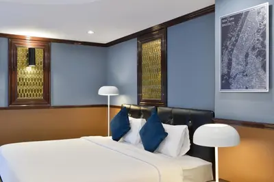 a bedroom with two beds with blue walls at The Breton Hotel Media in Bangkok