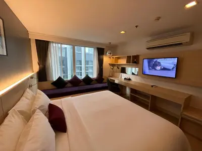 a hotel room with a bed and a flat screen tv at Arize Hotel Sukhumvit in Bangkok