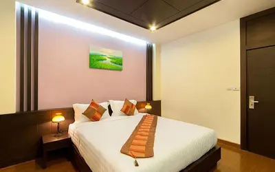a hotel room with a bed with a tie on it at Tara Place Hotel Bangkok in Bangkok