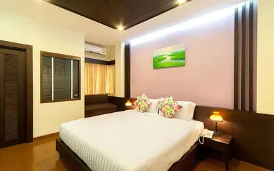 a bedroom with a large white bed with pillows at Tara Place Hotel Bangkok in Bangkok