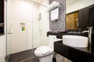 a bathroom with a toilet and a sink and a shower at Tara Place Hotel Bangkok in Bangkok