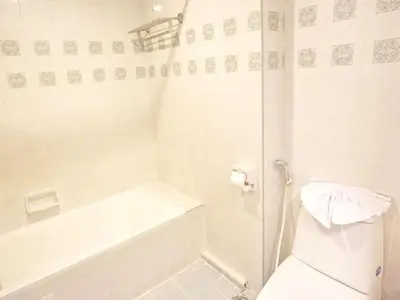 a white bathroom with a tub and a toilet at Bay Hotel Srinakarin in Bangna