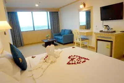 a bedroom with a large bed with red rose petals on it at Bay Hotel Srinakarin in Bangna