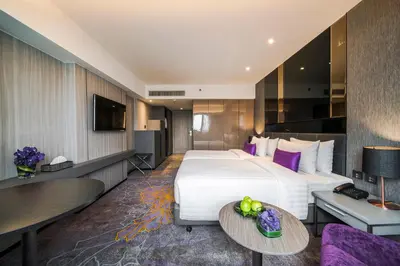 a hotel room with a large bed and a table at Hotel JAL City Bangkok in Bangkok