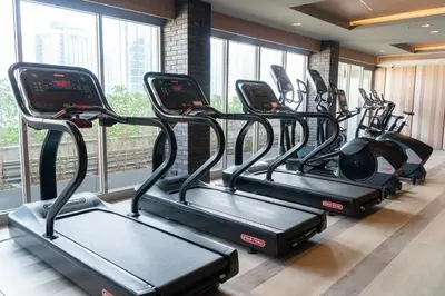 a row of treadmills in a gym with windows at Hotel JAL City Bangkok in Bangkok