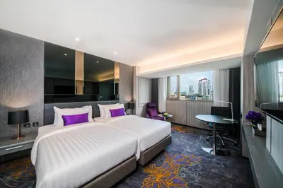 a bedroom with a large white bed with purple pillows at Hotel JAL City Bangkok in Bangkok