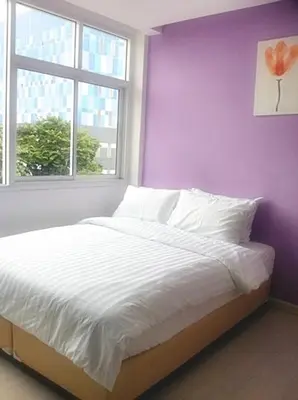 a bedroom with a bed with a purple wall and a window at Nantra Ekkamai Hotel in Bangkok