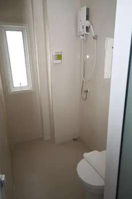 a bathroom with a shower and a toilet and a window at Nantra Ekkamai Hotel in Bangkok