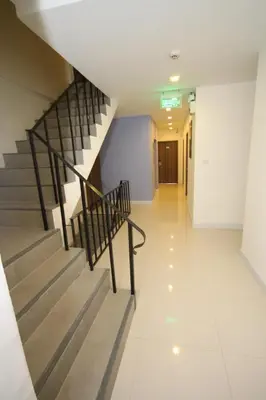 a hallway with a staircase in a building at Nantra Ekkamai Hotel in Bangkok