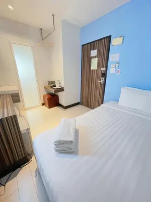 a bedroom with a large white bed with towels on it at Nantra Ekkamai Hotel in Bangkok
